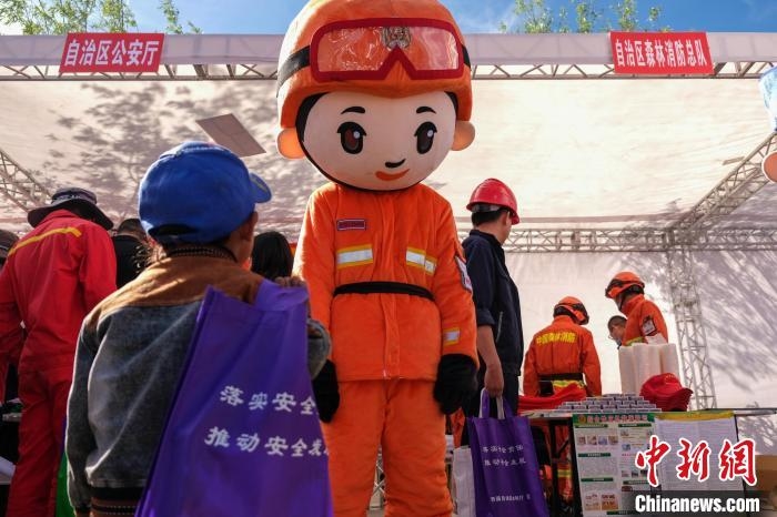 活動(dòng)現(xiàn)場(chǎng)，一位孩子好奇地看著森林消防人偶。　江飛波 攝