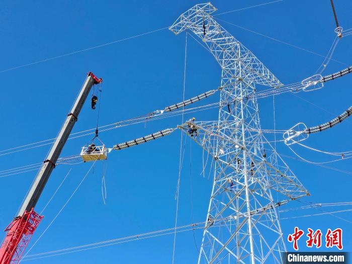 圖為施工人員在高空進行壓接工作。　鄒建華 攝