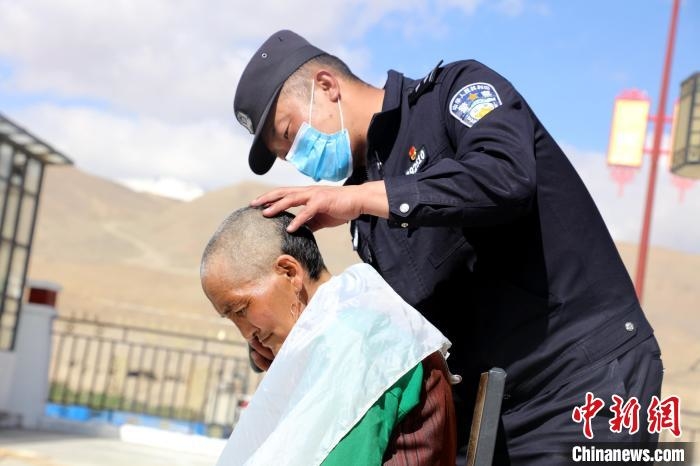 圖為普蘭邊檢站民警為敬老院老人理發。　格熱 攝
