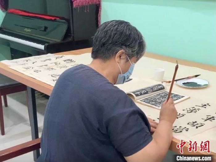 资料图：练习书法的老人。 徐婧 摄