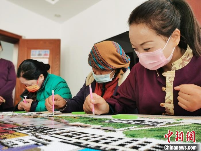 图为工作人员和残疾人共同制作手工作品。 张添福 摄 图为工作人员和残疾人共同制作手工作品。 张添福 摄