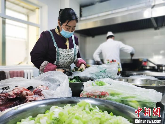 图为尖扎县残疾人托养服务中心食堂工作人员烹饪午餐。 张添福 摄 图为尖扎县残疾人托养服务中心食堂工作人员烹饪午餐。 张添福 摄