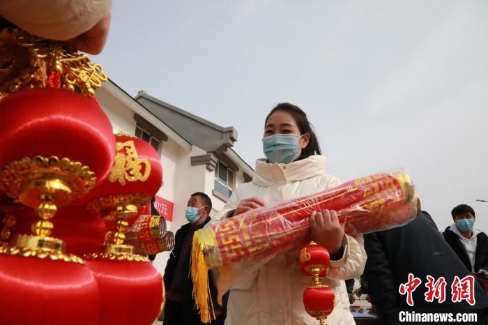 27日，蘭州新區(qū)為舟曲避險(xiǎn)搬遷移民送“春節(jié)包”，楊周馬草前往領(lǐng)取，紅色寓意來年的日子紅紅火火。　魏建軍 攝