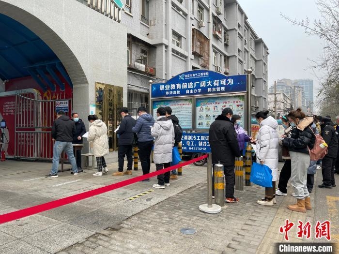 资料图:北京一考点外,考生正在排队进入考场。 任靖 摄 点击进入下一页