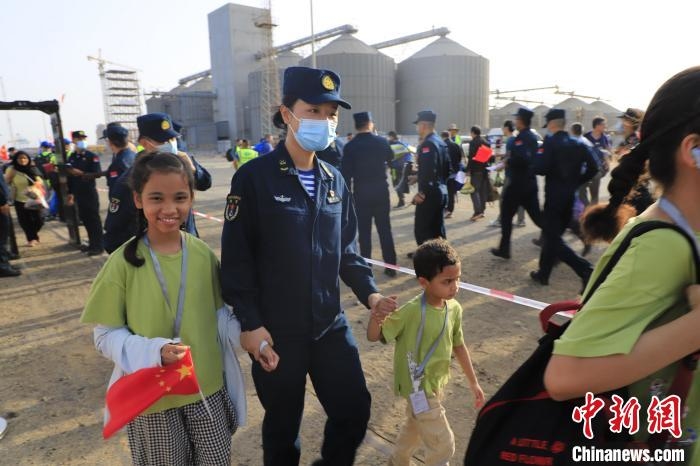 當地時間4月26日，海軍軍艦赴蘇丹緊急撤離我在蘇丹人員。圖為海軍官兵手牽著兒童通過安檢。　丁家興 攝
