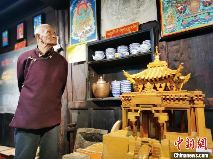 圖為古堡內的藝人桑杰展示自己的雕刻作品。　張添福 攝