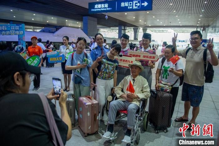 成都東站站臺乘客與車站工作人員合影留念。　劉忠俊　攝