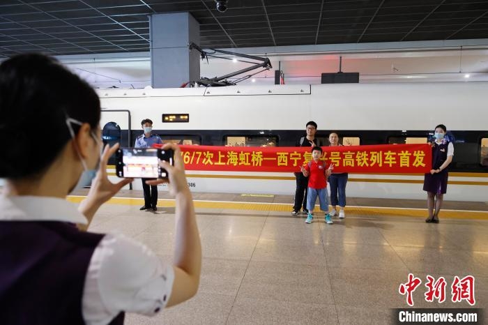 旅客和孩子在G3176/7次復興號高鐵列車前合影?！∫罅⑶?攝