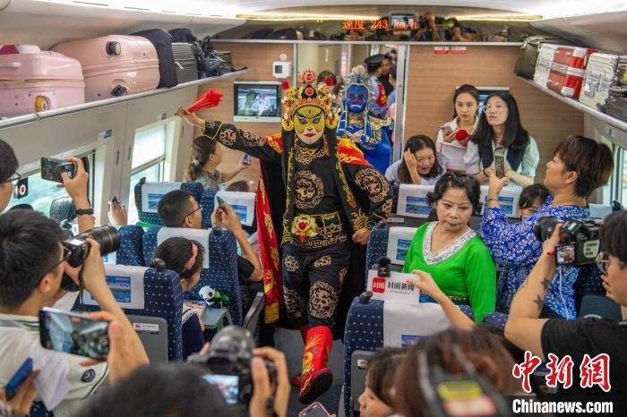 成都直達香港列車上文藝工作者表演川劇變臉，吸引了乘客和媒體。　劉忠俊　攝