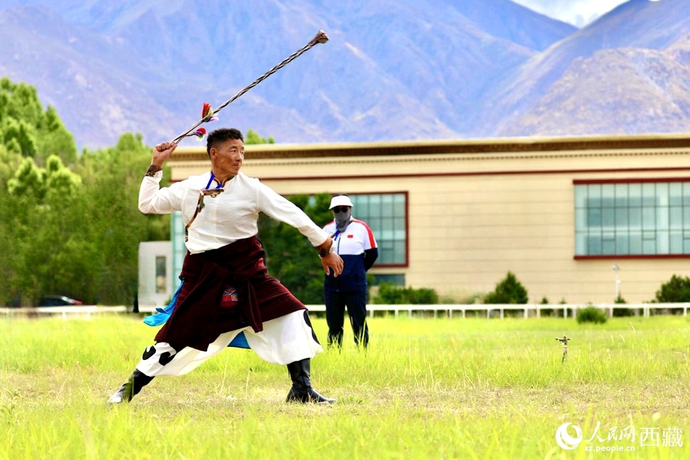 參賽選手在拉薩首屆農(nóng)牧民運(yùn)動(dòng)會(huì)上進(jìn)行“古朵”比賽（“古朵”指的是用牦牛毛或者山羊毛編織成的拋石繩，可以將石頭投擲到較遠(yuǎn)的地方，是牧民們用來放牧的工具）。