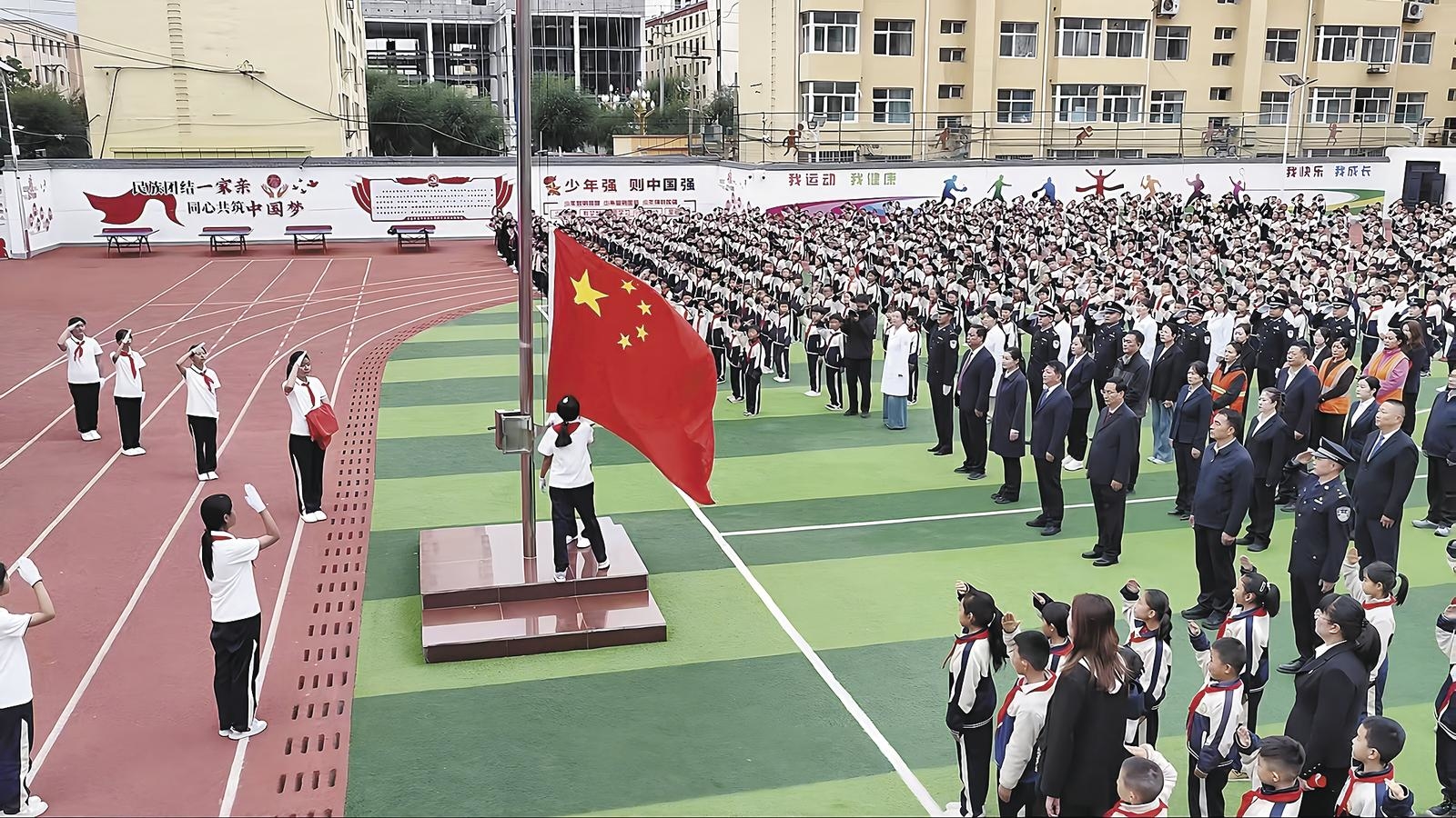 同仁市在市第三完全小学隆重举行“同升一面旗,共爱一个国”主题升旗仪式。尼玛才让 摄