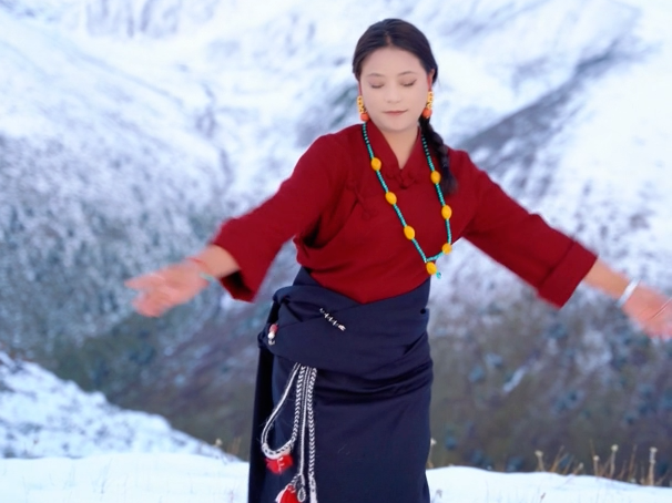 A Tibetan woman dances on a snow mountain in Dawu County, Garze Tibetan Autonomous Prefecture, Sichuan Province