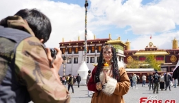 Global tourists dressed in Tibetan attire experience local culture in Lhasa