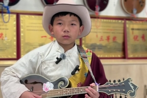 A primary school student plays the traditional Tibetan Dra'nyen