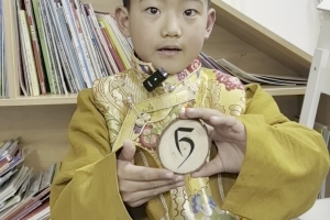 A child from the Fifth Kindergarten in Zhidoi County, Yushu City celebrates World Book Day